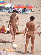 Long haired hottie lays around nude at the beach