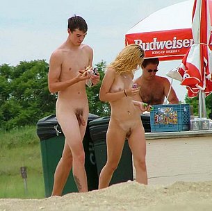 Nude teen friends play around at a public beach